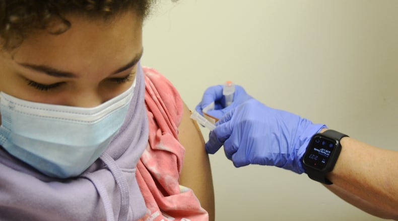 Brooklyn Brundidge, 12, a seventh-grader at Garfield Middle School in Hamilton, receives a vaccine shot on Wednesday, Sept. 14, 2022, from Public Health Nurse Betsy Waldeck at the Butler County General Health District clinic in downtown Hamilton. MICHAEL D. PITMAN/STAFF