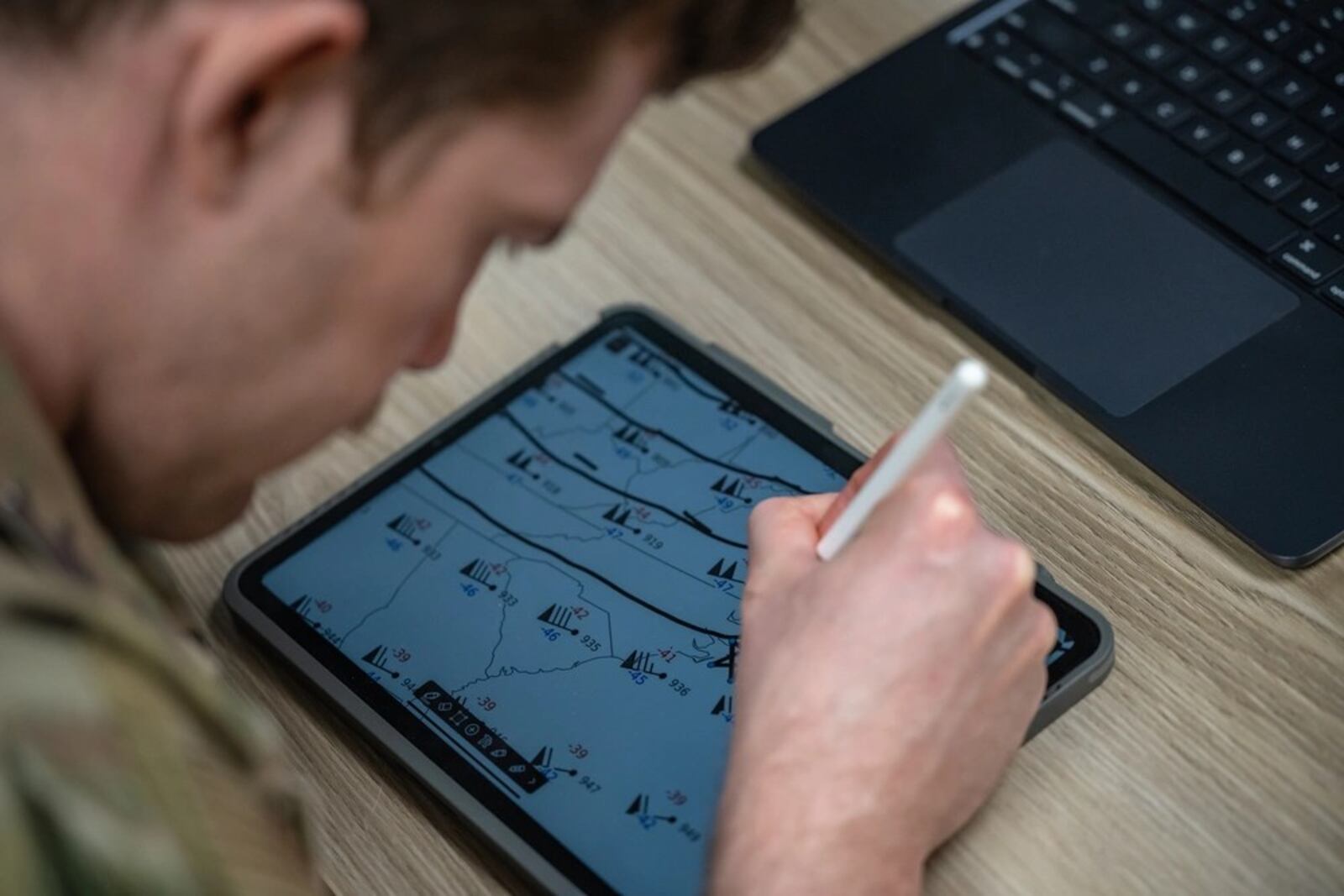 An Air Force Institute of Technology graduate student of meteorology, illustrates a contour weather map during class at Wright-Patterson Air Force Base, April 4, 2025. AFIT is a postgraduate institution and provider of professional and continuing education for service members. (U.S. Air Force photo by Daniel Peterson)