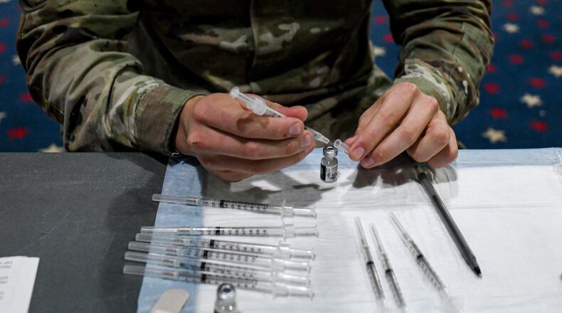 FILE — A soldier prepares vaccine doses for administration at Fort Bragg, N.C., Feb. 24, 2021. American soldiers who have yet to be vaccinated against the coronavirus will be immediately discharged, the Army said on Wednesday, Feb. 2, 2022, joining other branches of the military, including the Air Force, that have already begun dismissing vaccine holdouts. (Kenny Holston for The New York Times)