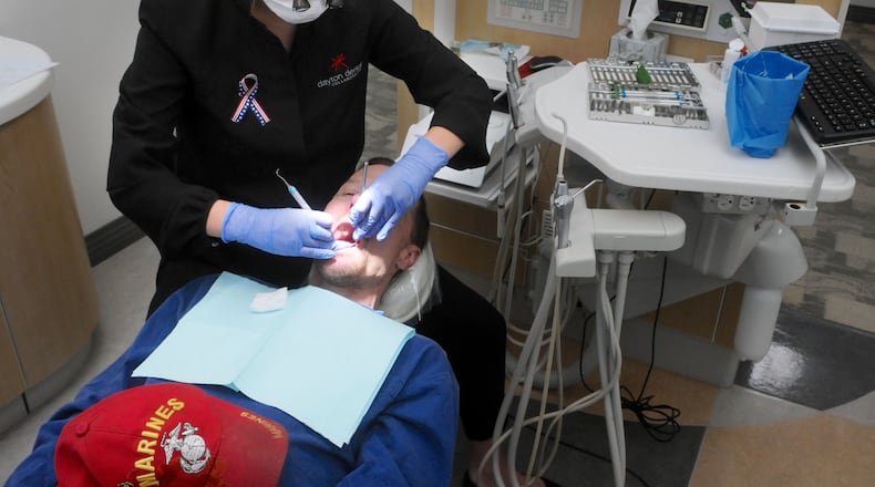 FILE: Veteran Paul Gabriel has his teeth cleaned and checked free of charge by dental hygienist Tabatha Whitaker at the Dayton Dental Collaborative during the Veterans Appreciation Day. Marshall Gorby/Staff