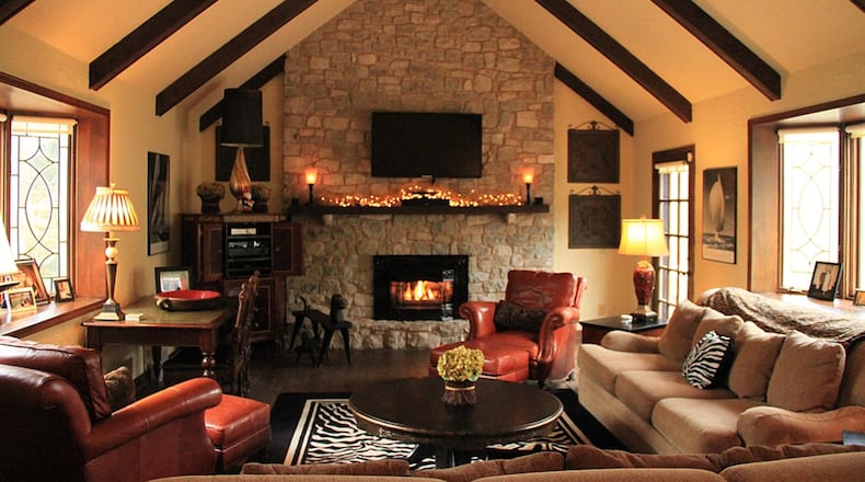 In the family room random-width, pegged wood planks cover the floor. Under a beamed cathedral ceiling, the natural stone fireplace has a raised hearth and a rustic wood mantel.