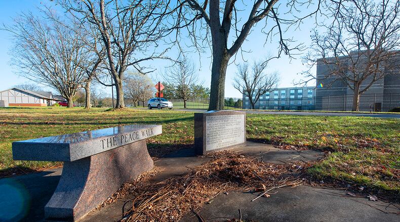 A bench and plaque commemorate the Peace Walk, a winding sidewalk between the Hope Hotel (background), which served as site of the official negotiations leading to the Dayton Peace Accords, and Visiting Officer Quarters on Wright-Patterson Air Force Base, where the diplomats stayed. The unofficial talks that happened as the diplomats walked back and forth are credited with playing a role in the successful end of the Bosnian War. U.S. AIR FORCE PHOTO/R.J. ORIEZ