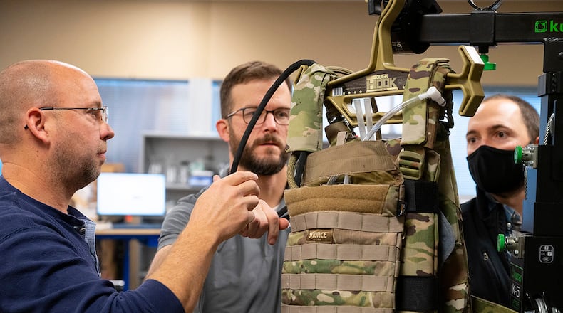 Matthew Sunday (left) and Joe Althaus (center), Wright Brothers Institute Rapid Innovation Program engineers, and Mike Moulton, an Air Force Research Laboratory engineer, work on the liquid-cooled plate carrier prototype in a lab in this 2022 photo. AIR FORCE PHOTO/R.J. ORIEZ