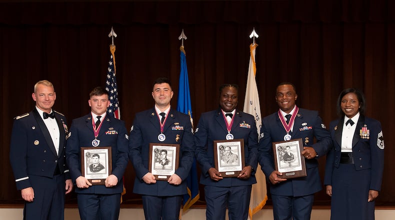 Col. Christopher Meeker (left), 88th Air Base Wing and installation commander, and Chief Master Sgt. Sharma Haynes (right), 88th Comptroller Squadron senior enlisted leader, stand with the honor graduates of Airman Leadership School Class 22-F on Aug. 18 at Wright-Patterson Air Force Base. U.S. AIR FORCE PHOTO/JAIMA FOGG