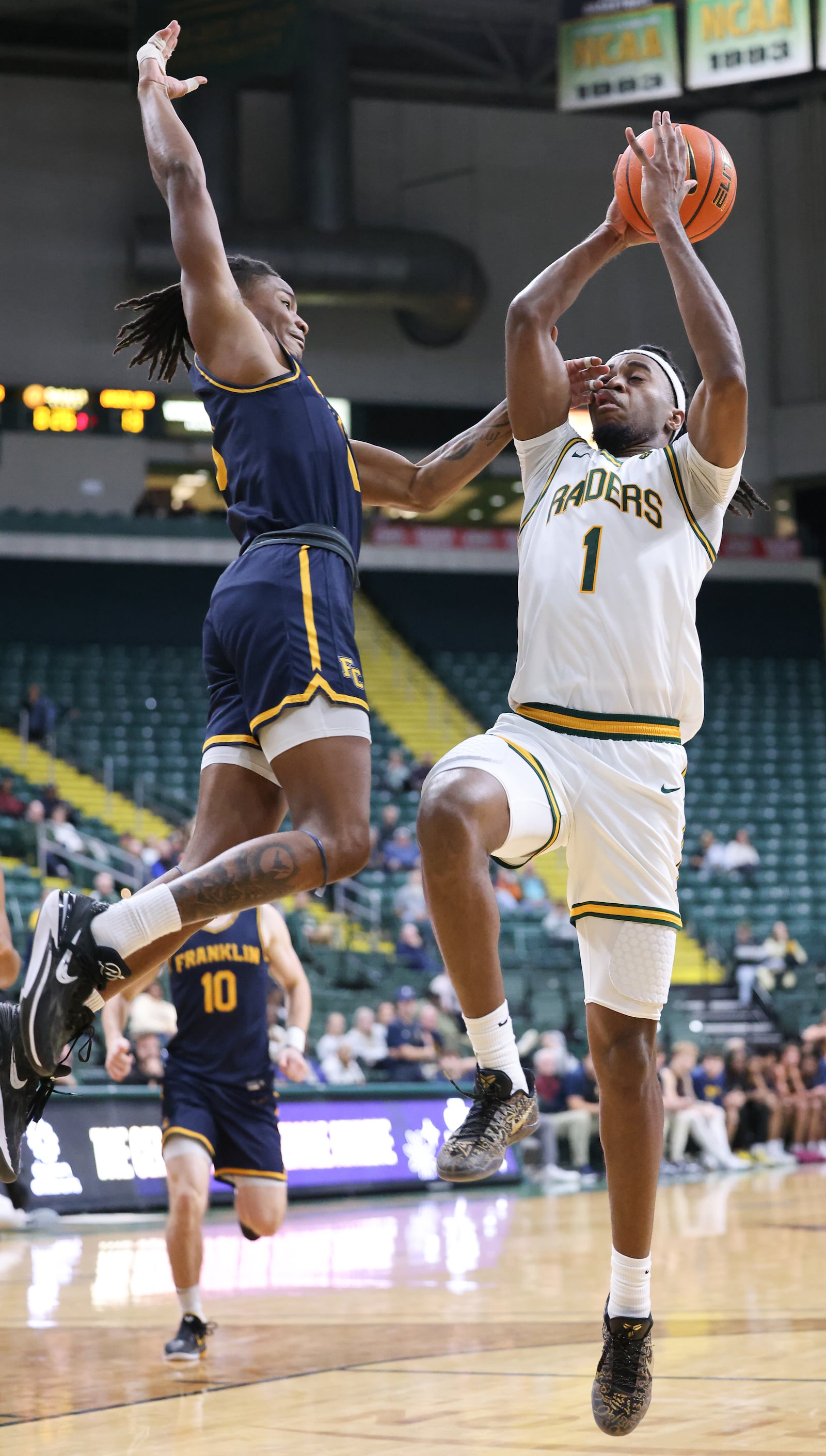 Wright State senior forward Bryan Etumnu shoots with pressure from Franklin College's LeBron Bennie-Powell during a season opener on Monday, Nov. 3 at Ervin J. Nutter Center. Etumnu scored seven points and had seven rebounds and four assists. BRYANT BILLING/STAFF
