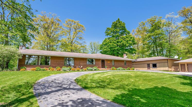 The front of the wood-sided ranch home has a circular asphalt driveway and a detached three-car garage. Contributed photos