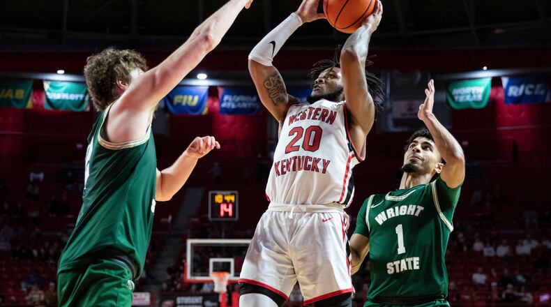 Western Kentucky guard Dayvion McKnight (20) shoots a layup as Wright State center AJ Braun and guard Trey Calvin (1) defend during an NCAA college basketball game Saturday, Dec. 10, 2022, in Bowling Green, Ky. (Grace Ramey/Daily News via AP)