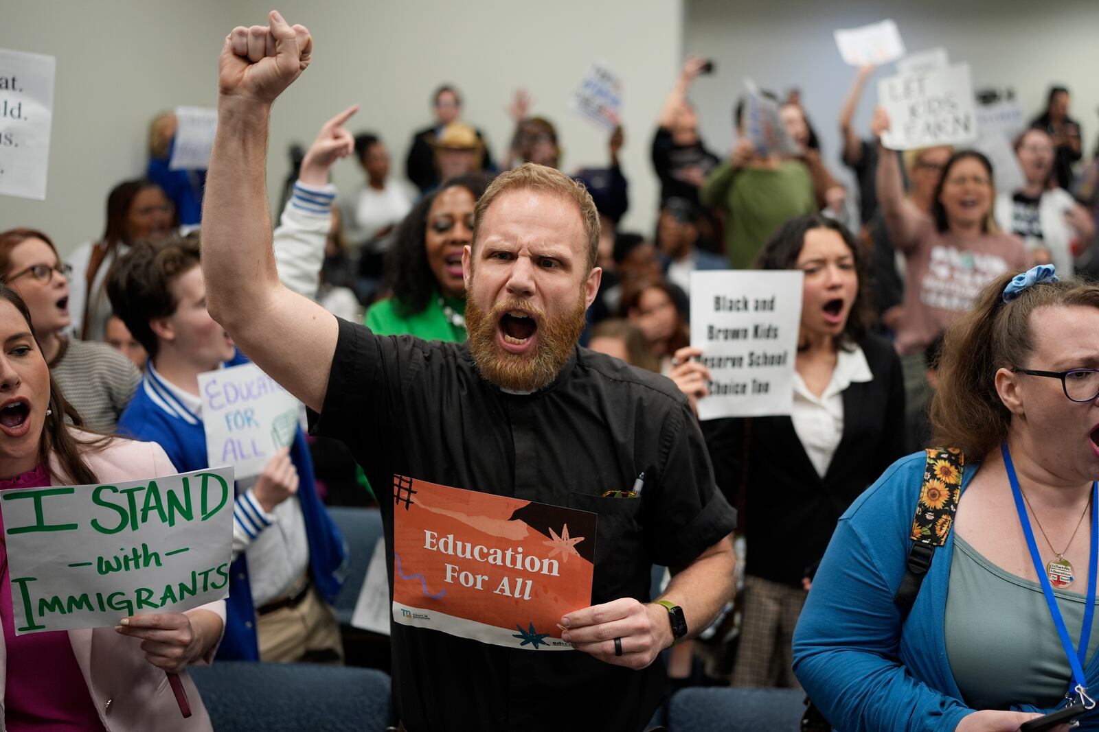 FILE - Rev. Eric Mayle, center, yells at lawmakers as a bill that would deny illegal immigrants access to education is passed in a House Education Committee hearing in Nashville, Tenn., March 26, 2025. (AP Photo/George Walker IV, File)