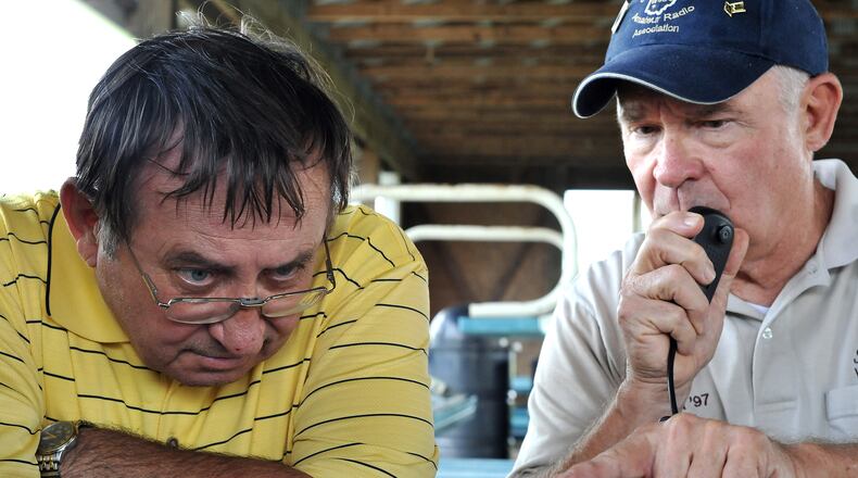 Carl Miller, left, and Bob Beach try to dial in a contact on a ham radio Saturday, June 25 during the Clark County Amateur Radio Association's annual Field Day event at Mid-Ohio Harley Davidson. Staff photo by Bill Lackey