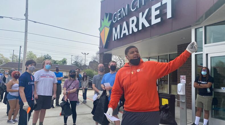 Chaz Amos, center, explains the protocol for the cleanup outside of the Gem City Market on Saturday. Amos was one of the organizers of the cleanup and is the CEO of I Love West Dayton. EILEEN McCLORY / STAFF