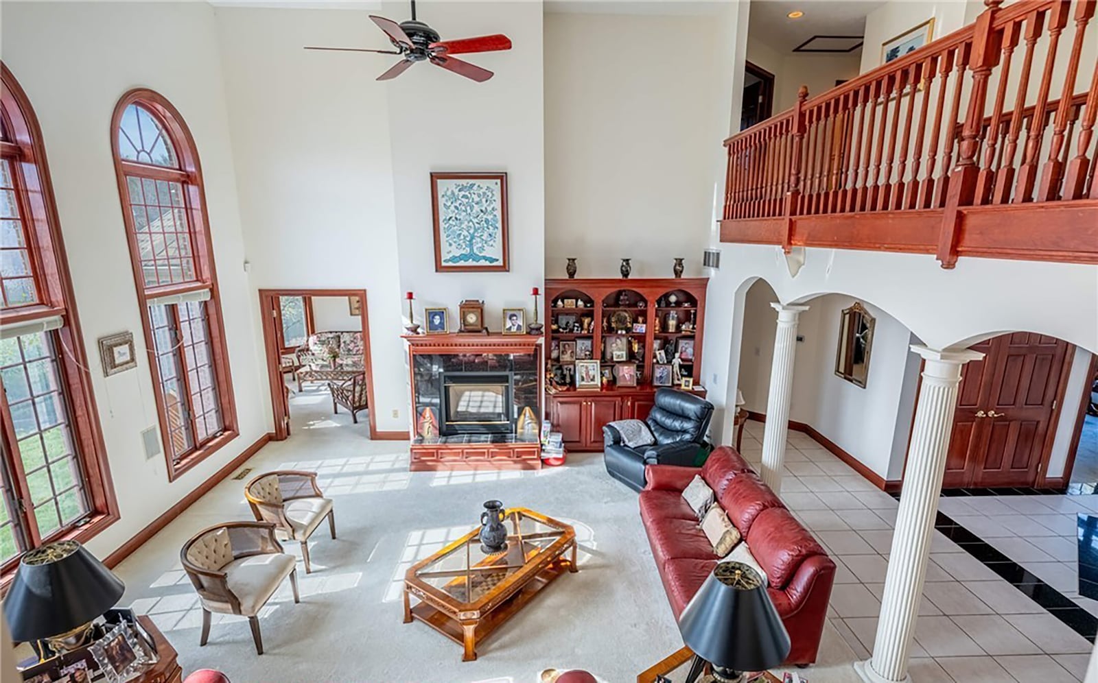 The two story great room has neutral carpeting, a ceiling fan, a wall of windows overlooking the lake and fireplace. CONTRIBUTED