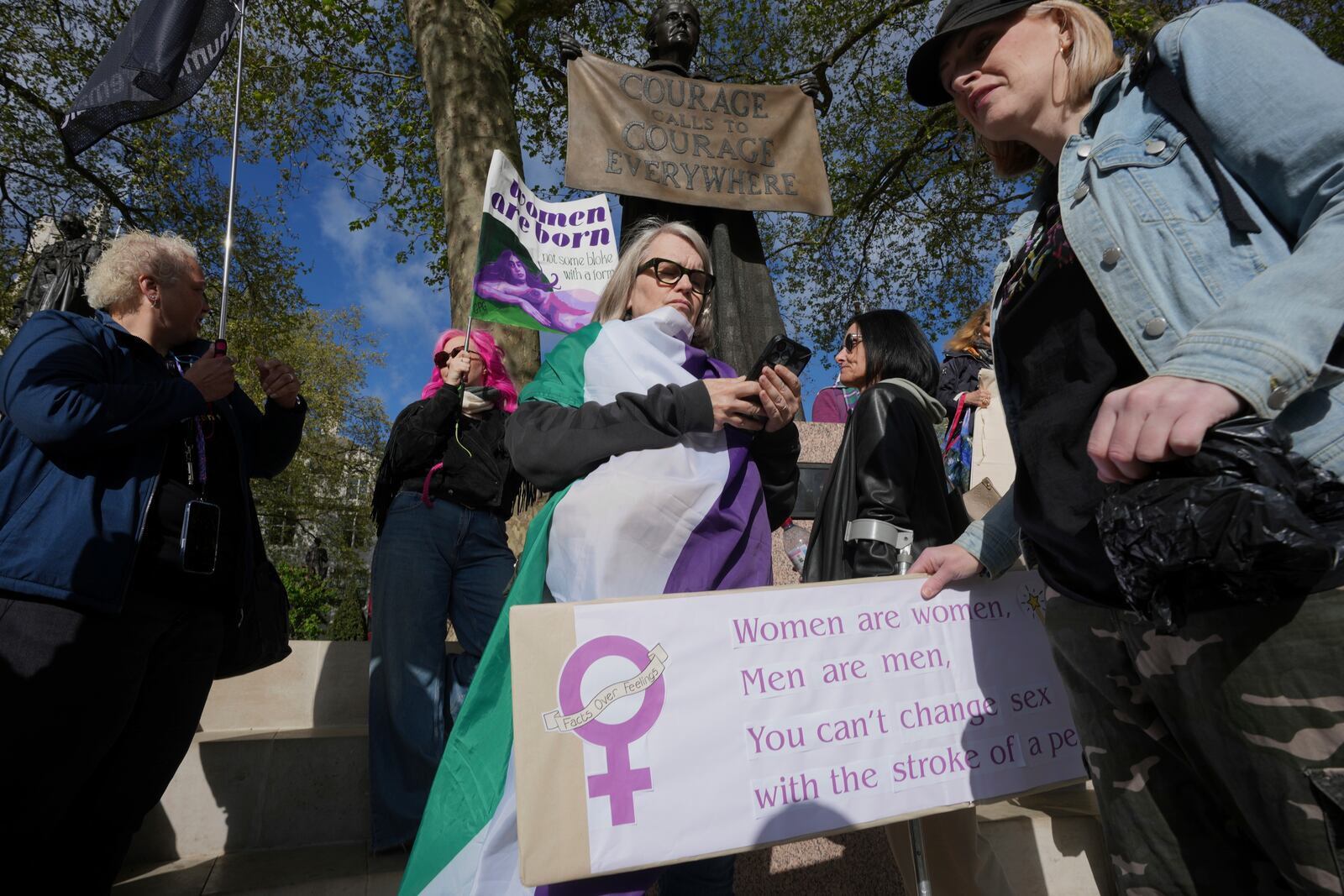 Women's rights activists hold placards outside the Supreme Court to challenge gender recognition laws, in London, Wednesday, April 16, 2025. (AP Photo/Kin Cheung)