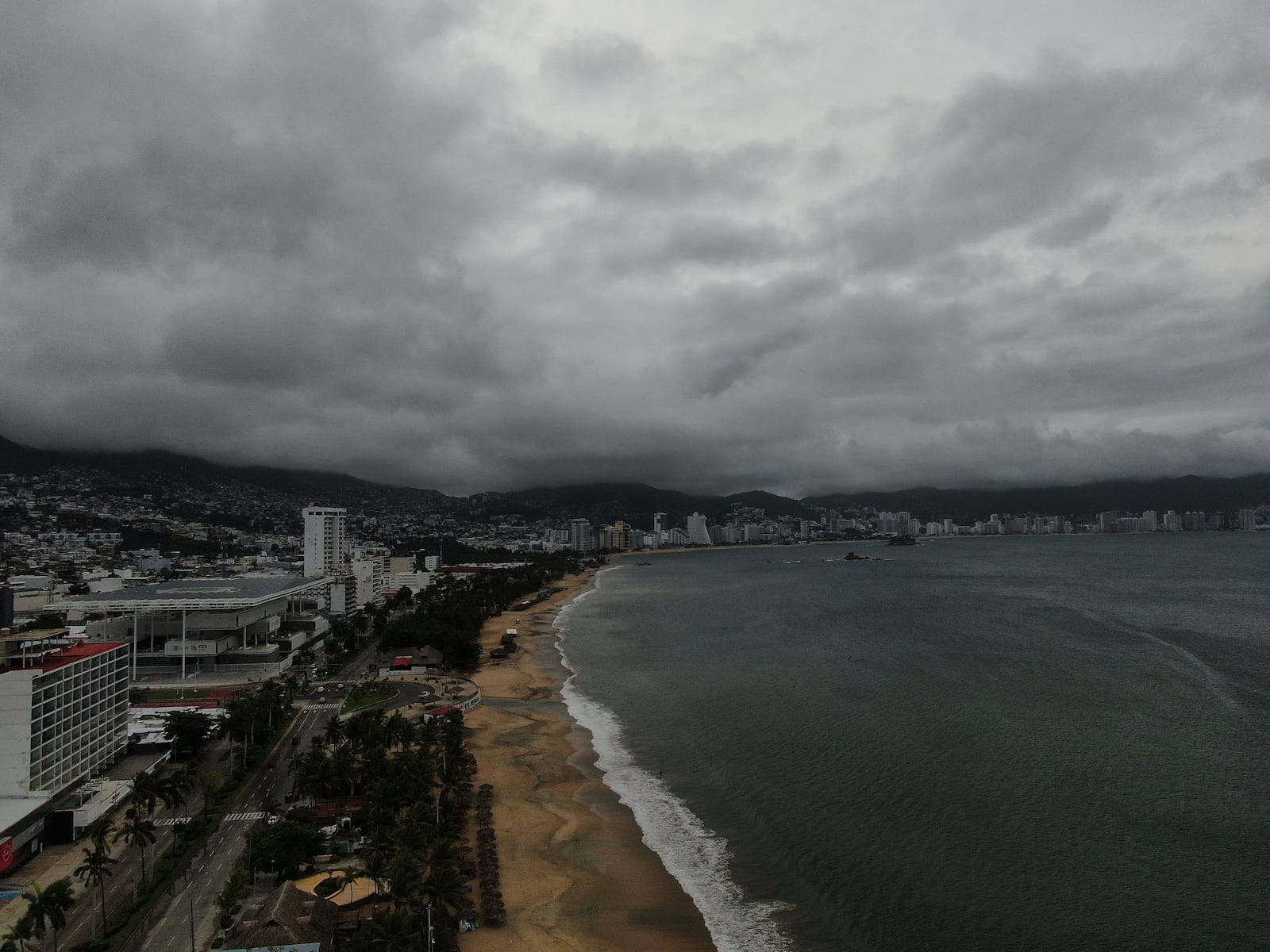 Acapulco Bay is void of boats while they are stored on shore as Hurricane Erick brings dark clouds, Thursday, June 19, 2025. (AP Photo/Fernando Llano)default