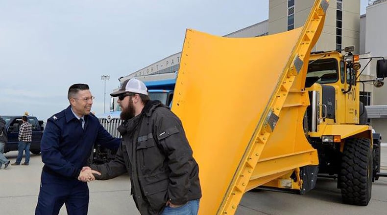 Col. Thomas P. Sherman, 88th Air Base Wing and installation commander, thanks one of the snow removal equipment operators along the parking ramp during the annual Snow Plow parade at Wright-Patterson Air Force Base Nov. 4. The Wright-Patt Snow Removal Team ensures Wright-Patt’s streets and runways are kept safe and operable during snowstorms. (U.S. Air Force photo/Ty Greenlees)