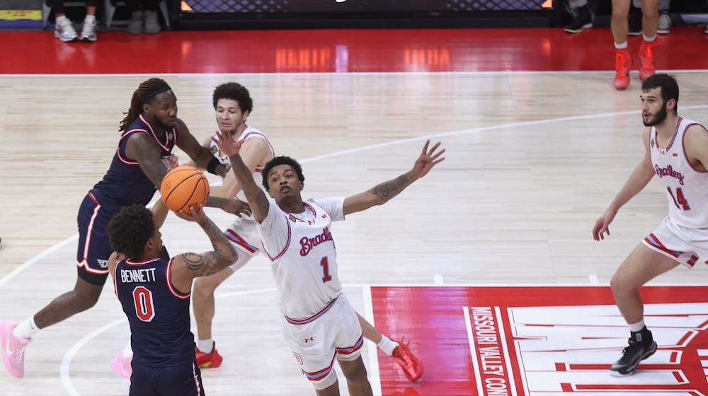 Dayton's Javon Bennett makes a 3-pointer and draws a foul in the final seconds of the first half against Bradley in the first round of the National Invitation Championship on Wednesday, March 18, 2026, at Carver Arena in Peoria, Ill. David Jablonski/Staff