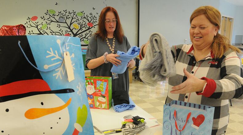 Cassondra Thorn, left and Shanda Sulfridge work to package Christmas presents for residents at Stillwater Center in Clayton on Dec. 19, 2023. MARSHALL GORBY\STAFF