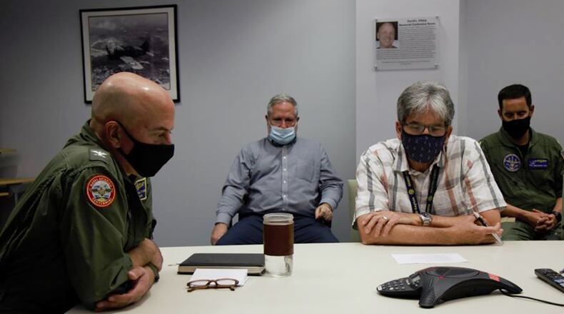 Dr. Michael Reddix (center), a researcher with the Naval Medical Research Unit-Dayton’s Naval Aerospace Medical Research Laboratory, and Capt. Walter Dalitsch III (left), NAMRU-D commander, attend a conference call in Dayton for recognition from Rear Adm. Bruce Gillingham, the Navy surgeon general. Reddix and his team were recognized by the U.S. Navy for their research toward development of a protective lens that mitigates the risk of lasers to pilot eyesight during flying operations. U.S. NAVY PHOTO/ELEXIA THARP