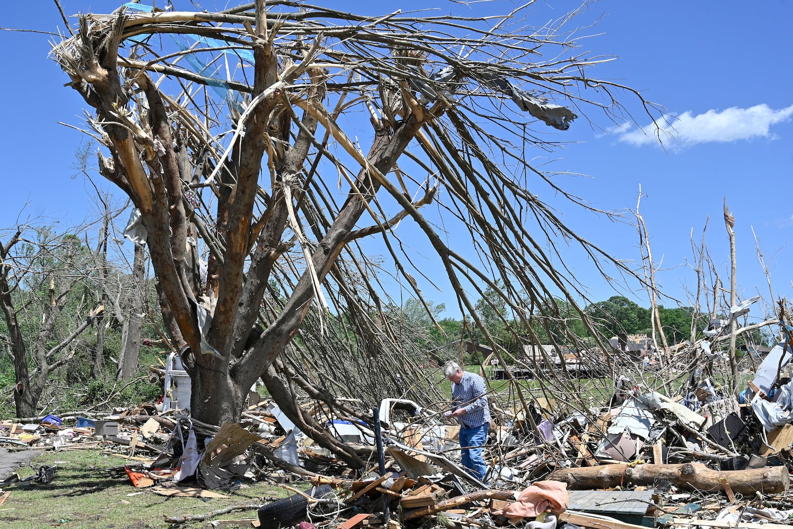 Dennis Clark goes through the remains of his house that was destroyed by severe weather in London, Ky., Saturday, May 17, 2025. (AP Photo/Timothy D. Easley)