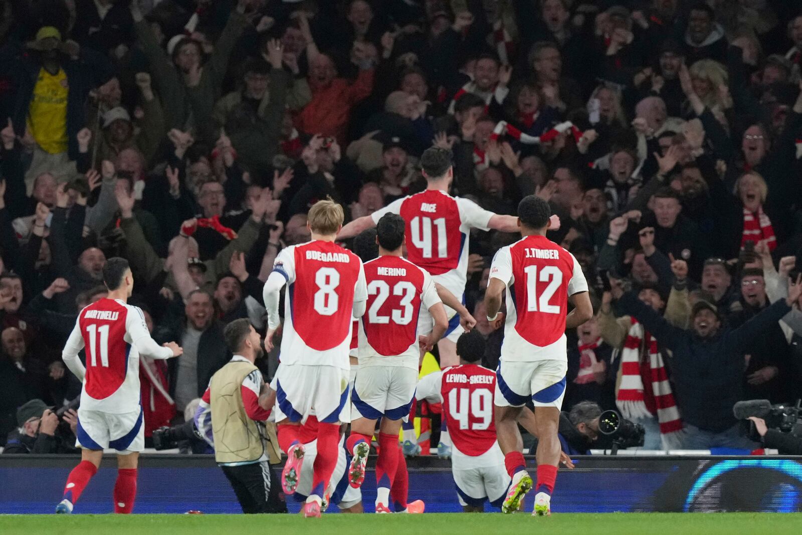 Arsenal's Declan Rice, top, celebrates after scoring his side's second goal during the Champions League quarterfinal first leg soccer match between Arsenal and Real Madrid at the Emirates Stadium in London, Tuesday, April 8, 2025. (AP Photo/Frank Augstein)