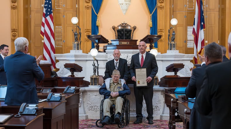 Jim Erisman, a 99-year-old World War II veteran from Farmersville, was honored by the Ohio Senate on Nov. 19, 2025. He's joined on the Senate floor by his son, Jim Erisman, Jr., and Sen. Steve Huffman, R-Tipp City. Courtesy Matt Shadle, Ohio Senate.