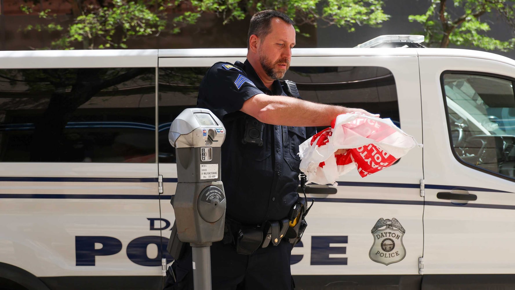 Officer removing no parking bag after NATO assembly