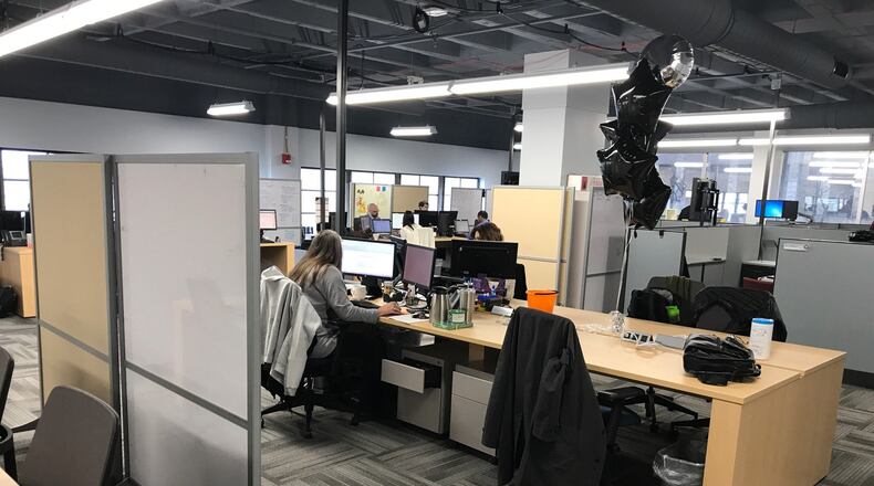 Taylor Communications employees work in their new office at 111 W. First St., Dayton. KAITLIN SCHROEDER/STAFF