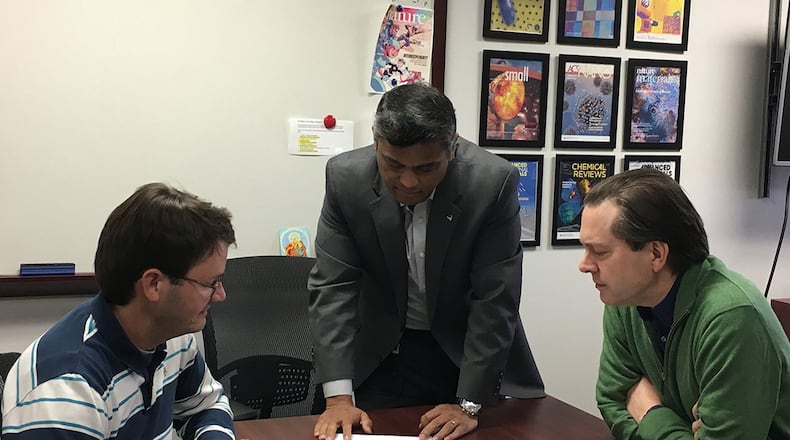 Air Force Research Laboratory project researchers Dr. Joseph Slocik (left), Dr. Rajesh Naik and Dr. Patrick Dennis review the recently signed licensing agreement that grants locally based innovators S.A.Wyze exclusive rights to use AFRL-developed ultra-stable antibody liquids technology for human diagnostic work. (U.S. Air Force photo/Kristi Singh)