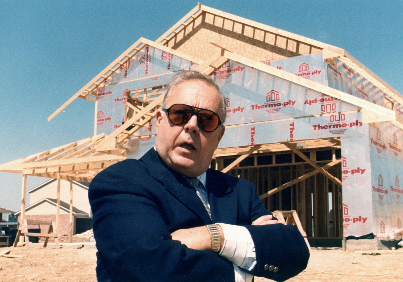 Charles Huber is shown posing in front of a Huber Home under construction in 1988.