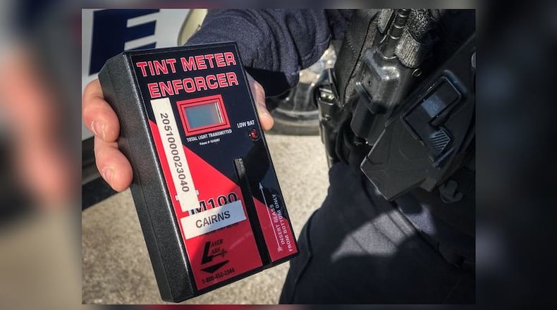Dayton police Sgt. Gordon Cairns holds up a tint meter that is used to test whether a car window tint is darker than allowed by Ohio law. JIM NOELKER/STAFF