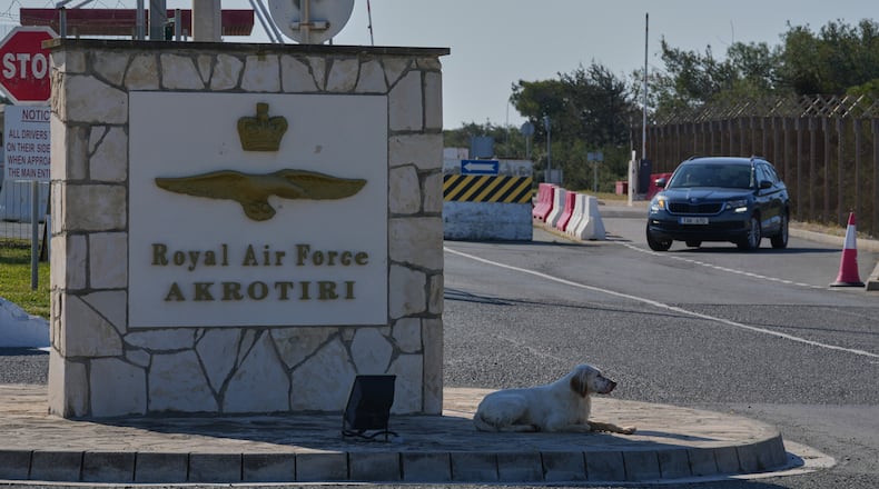 A dog sits at the main gate of the U.K.’s RAF Akrotiri air base after it was hit by a drone strike early morning near Limassol, Cyprus, Monday, March, 2, 2026. (AP Photo/Petros Karadjias)