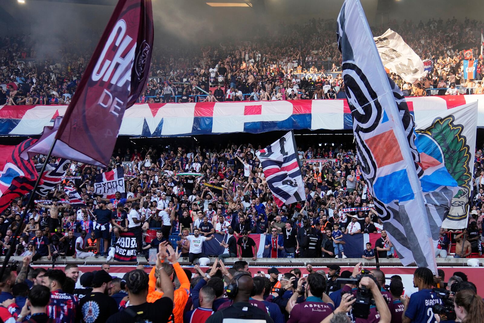 PSG's supporters celebrate winning the French League One championship title after the soccer match between Paris Saint-Germain and Angers at Parc des Princes stadium in Paris, Saturday, April 5, 2025. (AP Photo/Michel Euler)