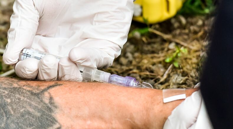 Middletown paramedics inject Narcan into a man after responding for a drug overdose behind the Midd-Town Carry Out on Central Avenue Monday, June 26, 2017. NICK GRAHAM/STAFF