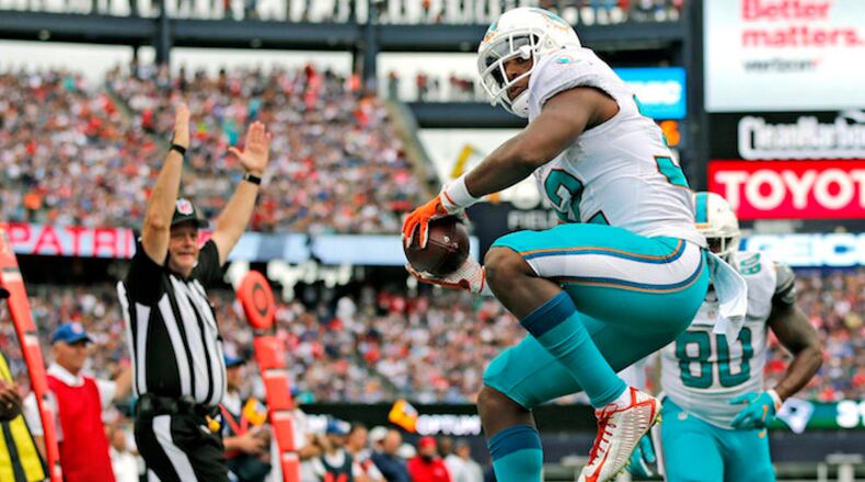 Miami Dolphins running back Kenyan Drake (32) celebrates after scoring late in the fourth quarter against the New England Patriots on September 18, 2016, at Gillette Stadium in Foxborough, Mass. (Al Diaz/Miami Herald/TNS)