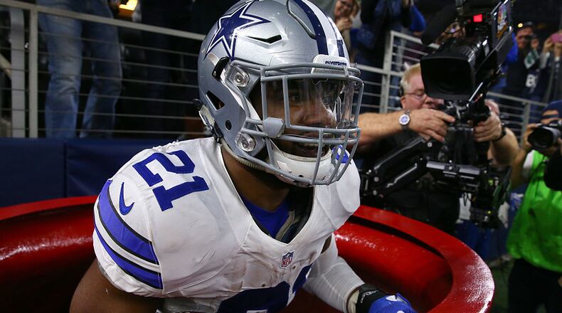 ARLINGTON, TX - DECEMBER 18: Ezekiel Elliott #21 of the Dallas Cowboys celebrates after scoring a touchdown by jumping into a Salvation Army red kettle during the second quarter against the Tampa Bay Buccaneers at AT&T Stadium on December 18, 2016 in Arlington, Texas. (Photo by Tom Pennington/Getty Images)