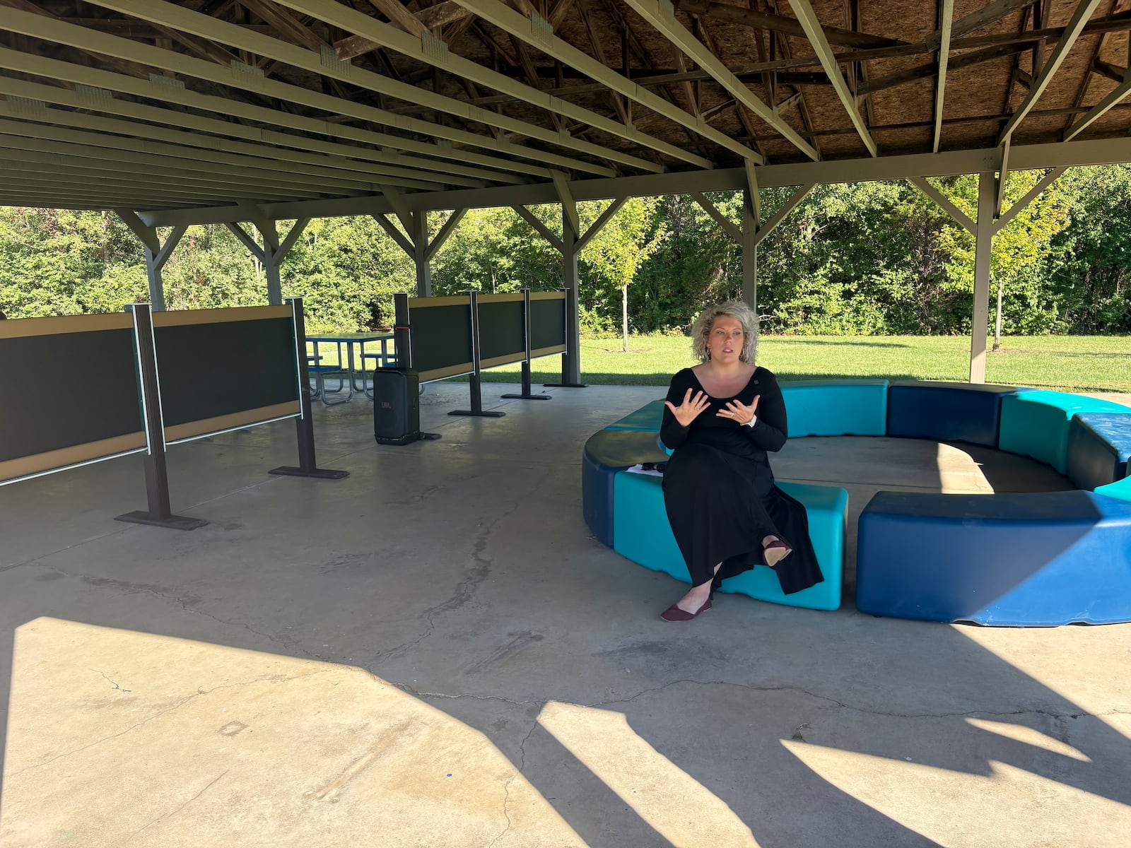 Krista Curry, a first grade teacher at Clearcreek Elementary School, sits on one of the benches Thursday, Oct. 9, 2025, as she talks about the new outdoor classroom in the shelter behind the school. JEN BALDUF/STAFF