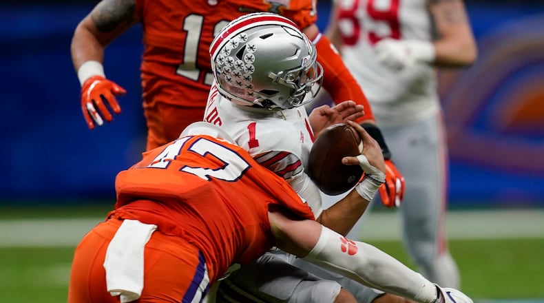 Ohio State quarterback Justin Fields gets hit by Clemson linebacker James Skalski during the first half of the Sugar Bowl NCAA college football game Friday, Jan. 1, 2021, in New Orleans. Skalski was ejected from the game for targeting. (AP Photo/Gerald Herbert)