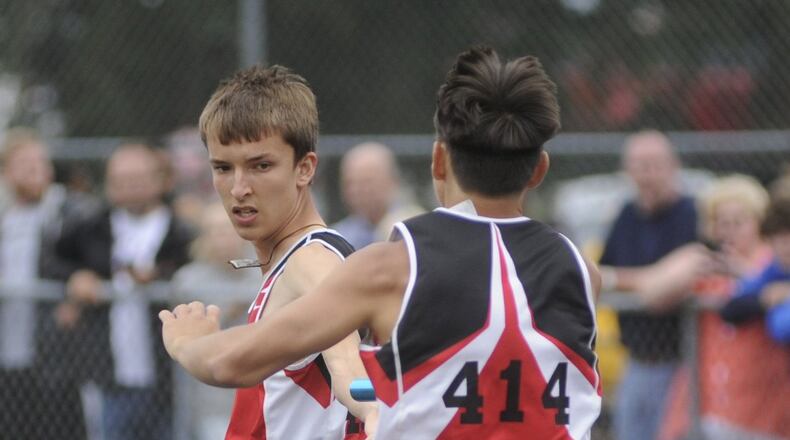 Alan Holdheide of Fort Loramie High School (right) passes the baton to Jake Rethman and the Redskins won the 4x800-meter relay during the D-III regional track and field meet at Troy’s Memorial Stadium on Wednesday, May 24, 2017. MARC PENDLETON / STAFF