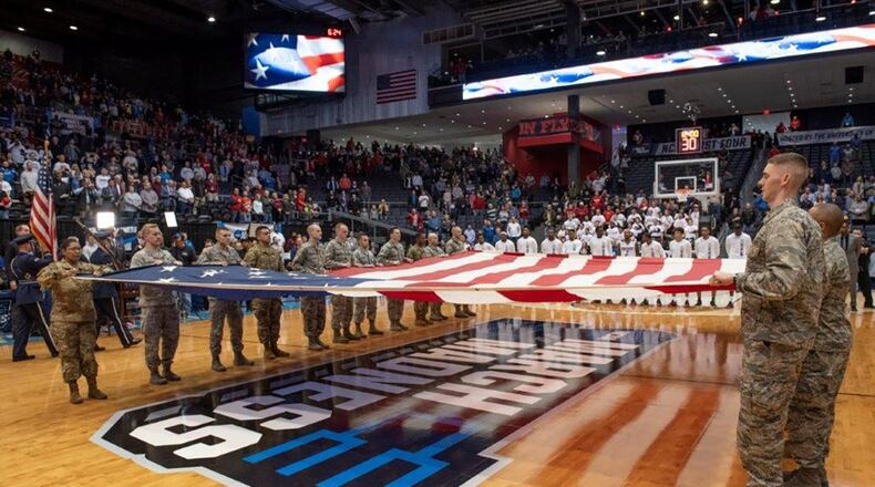Airmen from Wright-Patterson Air Force Base hold a large garrison-size American flag during the presentation of the colors and singing of the national anthem at the NCAA First Four Tournament March 19 at the University of Dayton Arena. (U.S. Air Force photo/Michelle Gigante)