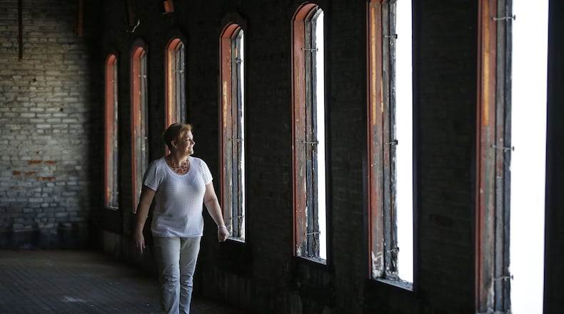 Amy Walbridge, Special Projects Administrator at City of Dayton, walks through the empty building at 210 Wayne Ave. that has been placed on the National Register of Historic Places, an important step forward for plans to redevelop the property into apartments and commercial space. TY GREENLEES / STAFF