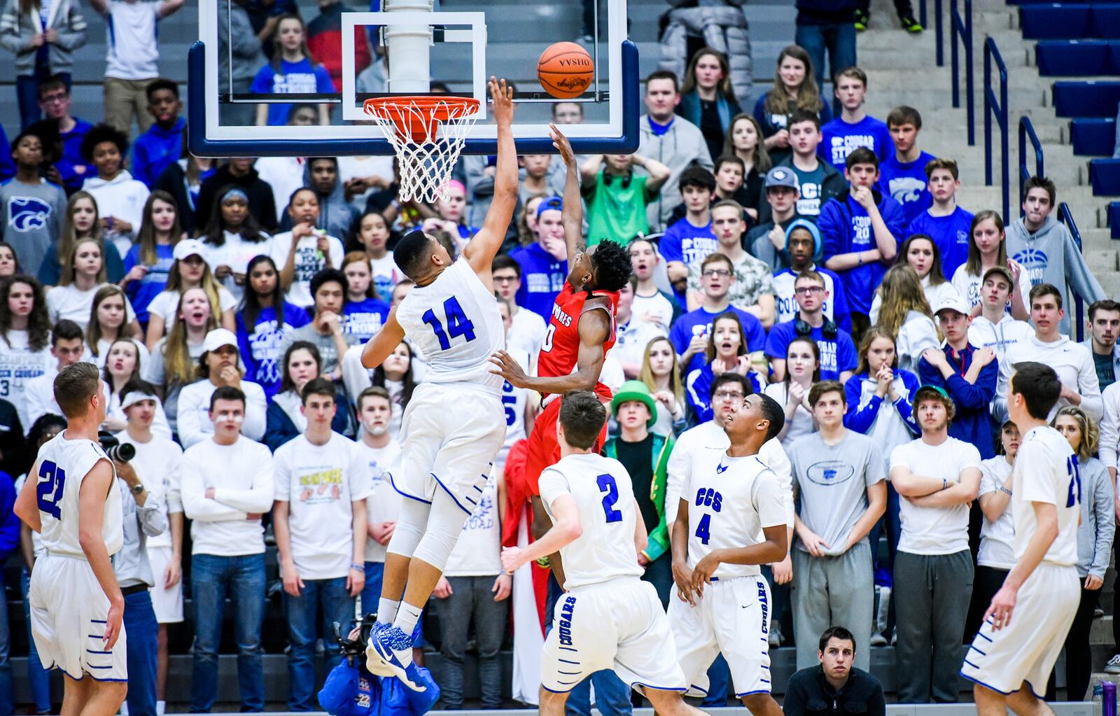 Cincinnati Christian’s fans get a good look at the Cougars’ Christian Keese (14) going one-on-one with Lima Perry’s Jakoby Lane-Harvey on Friday night during a Division IV regional final at Fairmont’s Trent Arena. NICK GRAHAM/STAFF