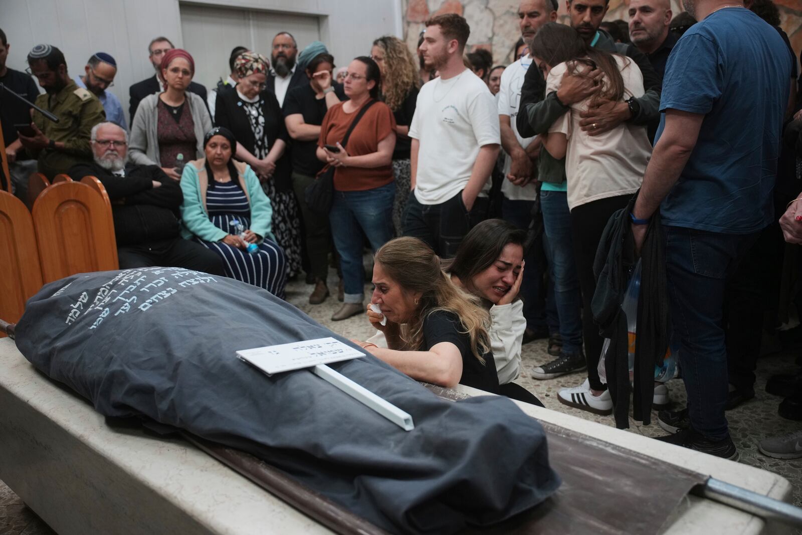Mourners react next to the body of Tzeela Gez, 37, an Israeli who was on her way to have her baby delivered when she was shot and killed by a Palestinian gunman in the occupied West Bank, during her funeral at Givat Shaul cemetery in Jerusalem on Thursday, May 15, 2025. (AP Photo/Ohad Zwigenberg)
