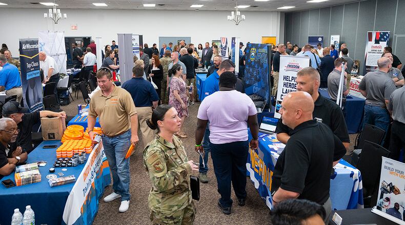 Master Sgt. Angie Cooper (center), U.S. Air Force School of Aerospace Medicine, talks with Crown Lift Trucks representatives in a room crowded with company recruiters and job hunters during the Hiring Our Heroes event June 22 at Hope Hotel near Wright-Patterson Air Force Base. More than 50 companies, with over 50,000 job openings, set up tables to talk with active-duty Airmen, recent retirees and spouses. U.S. AIR FORCE PHOTO/R.J. ORIEZ