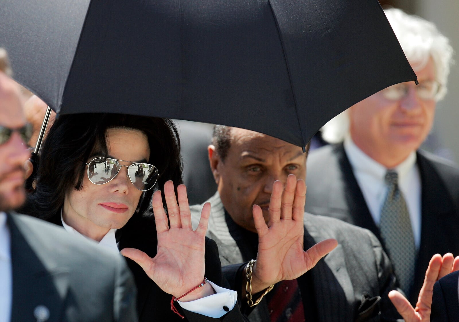 FILE - Michael Jackson waves as he leaves court with his father Joe, right, June 13, 2005, in Santa Maria, Calif. (AP Photo/Mark J. Terrill, File)