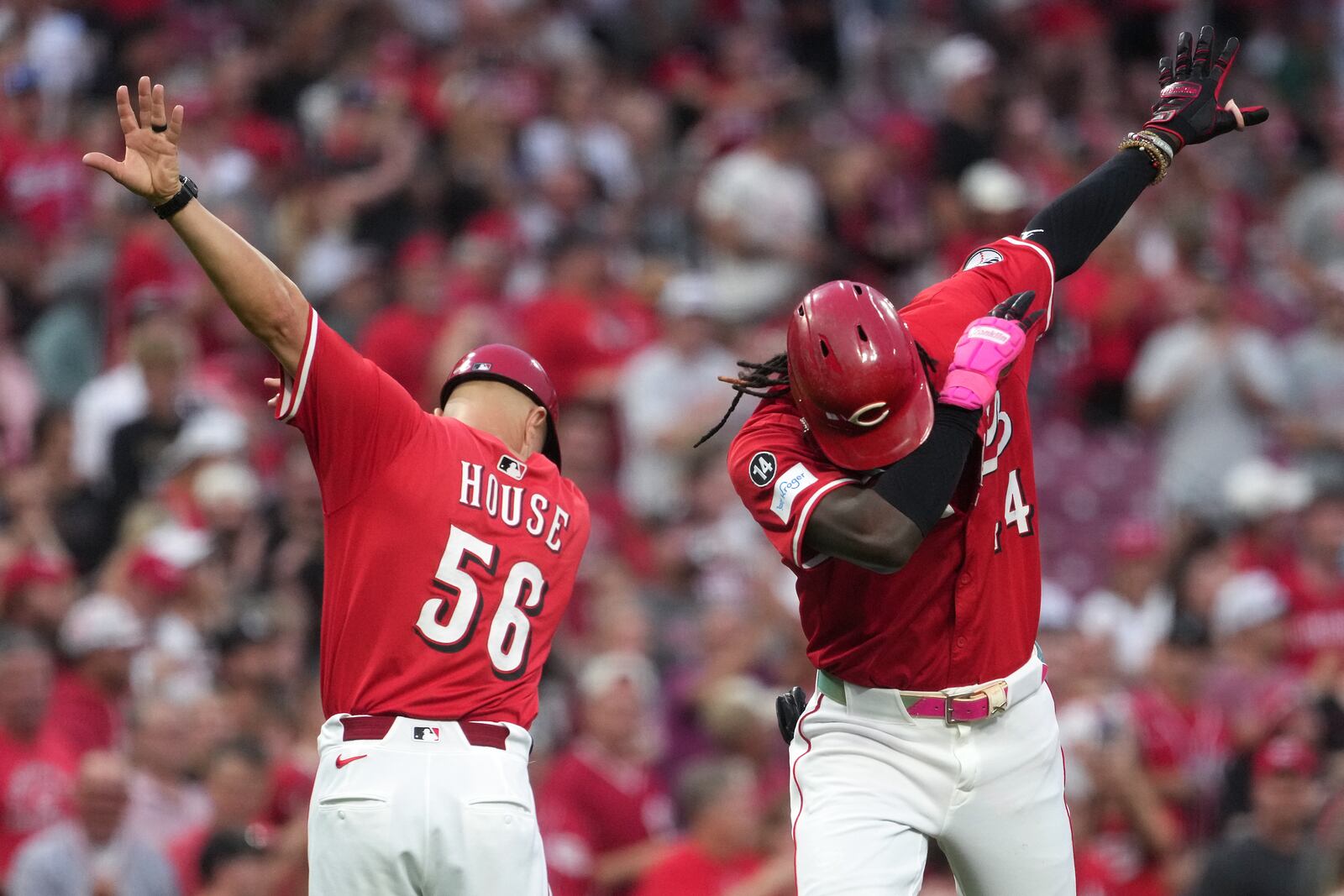 Cincinnati Reds' Elly De La Cruz, far right, celebrates a two-run home run with third base coach J.R. House, left, in the second inning of a baseball game against the Pittsburgh Pirates, Tuesday, Sept. 23, 2025, in Cincinnati. (AP Photo/Kareem Elgazzar)
