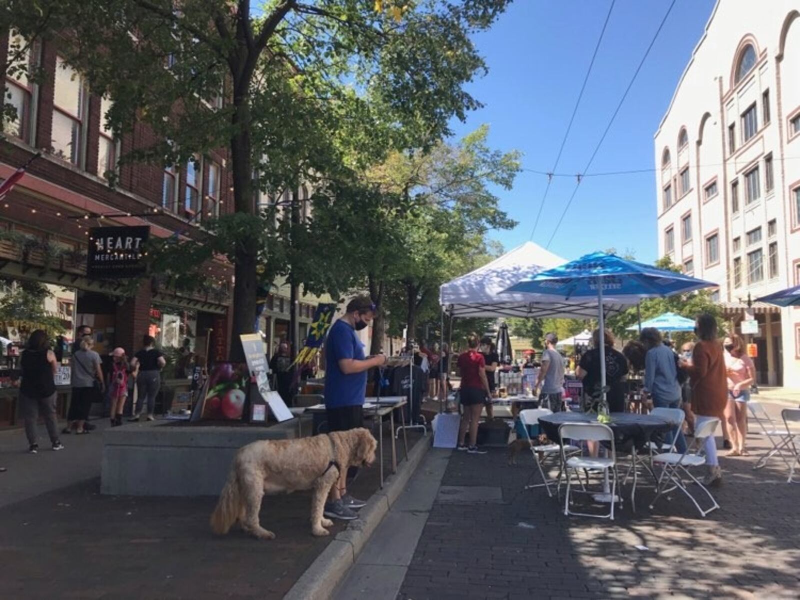 People enjoy the new pedestrian promenade on Fifth St. in the Oregon District on Saturday.