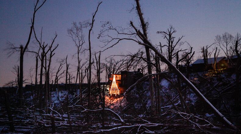 Allison Sandivar’s holiday display brightens the tornado-ravaged Stillwater River bank below her home in Harrison Twp. The Memorial Day tornado forced Sandivar from her home and her dog died within a week of the storm. Before the tornado it was difficult to see through the trees, she said. “At night it sparkles because you can see the city a little bit. And in the morning, you can see the sun rise a lot more than you used to,” she said. “I try to take a moment and appreciate the things I didn’t have before.” CHRIS STEWART / STAFF