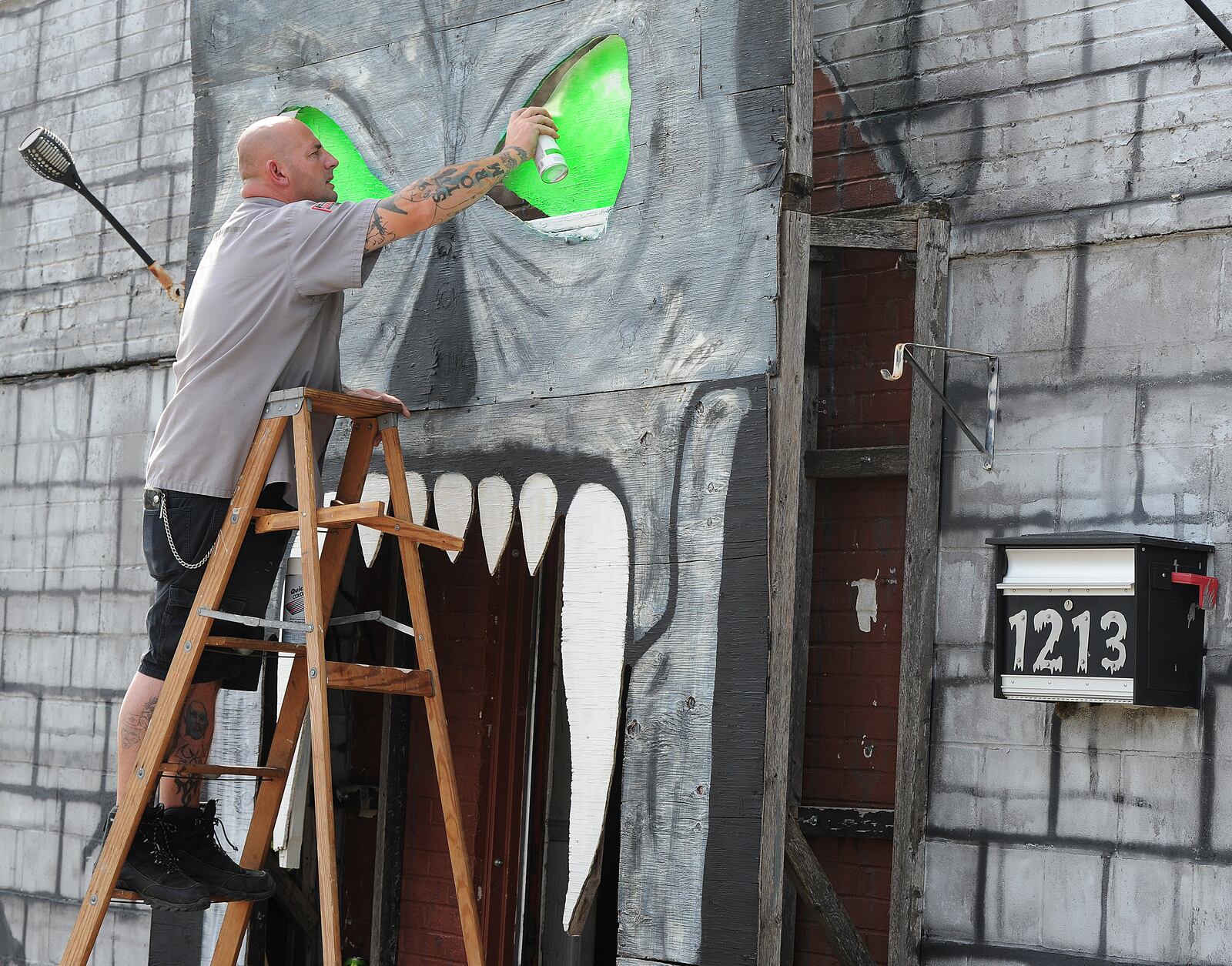 Jason Byrd, paints the eyes on the skull on the front of the Riverside Jaycees, Haunted House, located at 1213 Harshman Road. Byrd has been helping at the event for 35 years. MARSHALL GORBY\STAFF