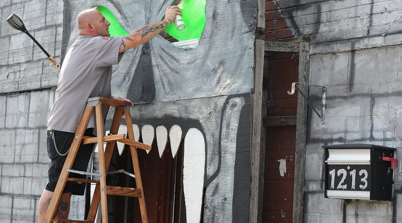 Jason Byrd, paints the eyes on the skull on the front of the Riverside Jaycees, Haunted House, located at 1213 Harshman Road. Byrd has been helping at the event for 35 years. MARSHALL GORBY\STAFF