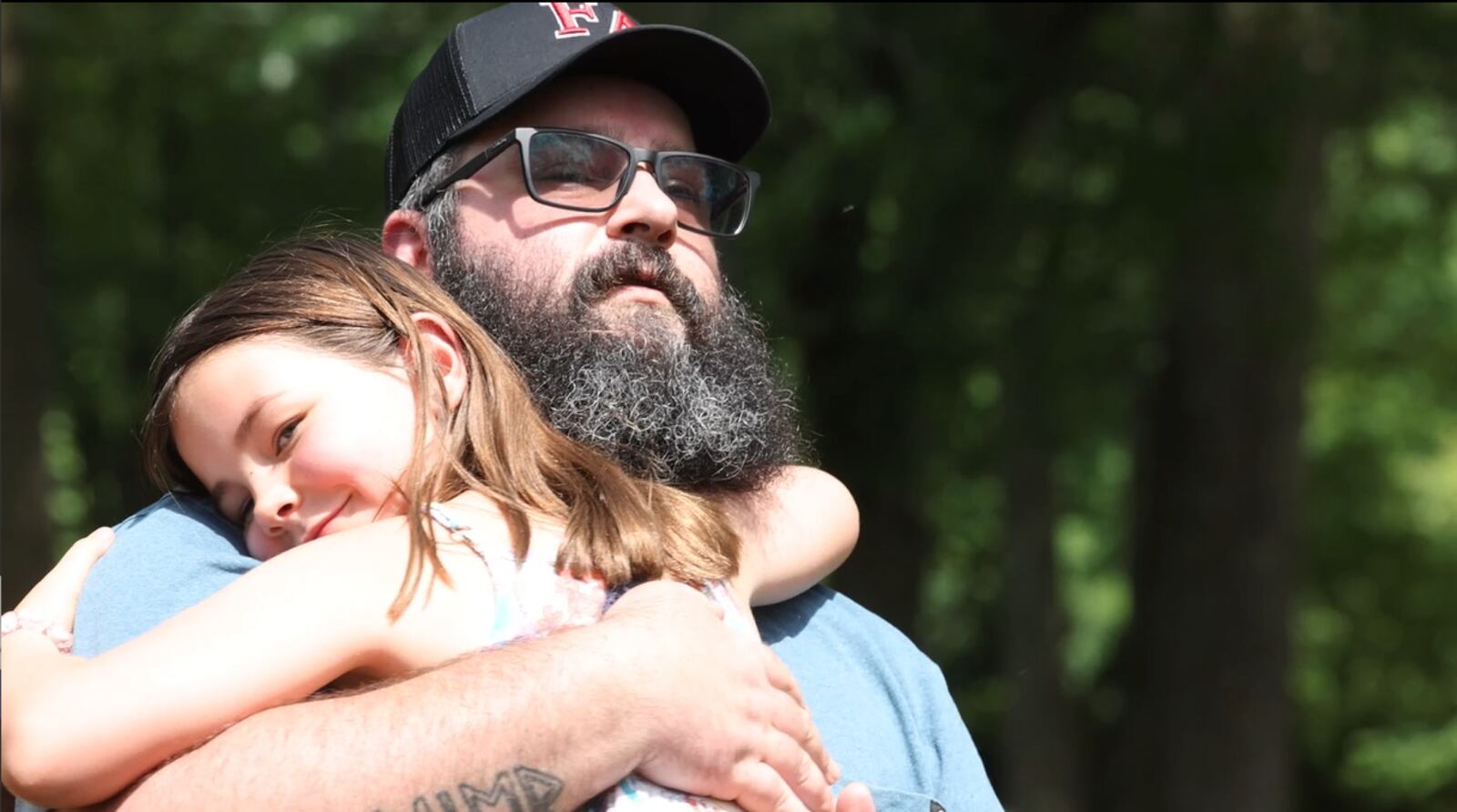 Miamisburg wounded veteran Paul Gibson hugs his daughter Coralee after receiving a all-terrane wheelchair from Freedom Alliance. JIM NOELKER/STAFF