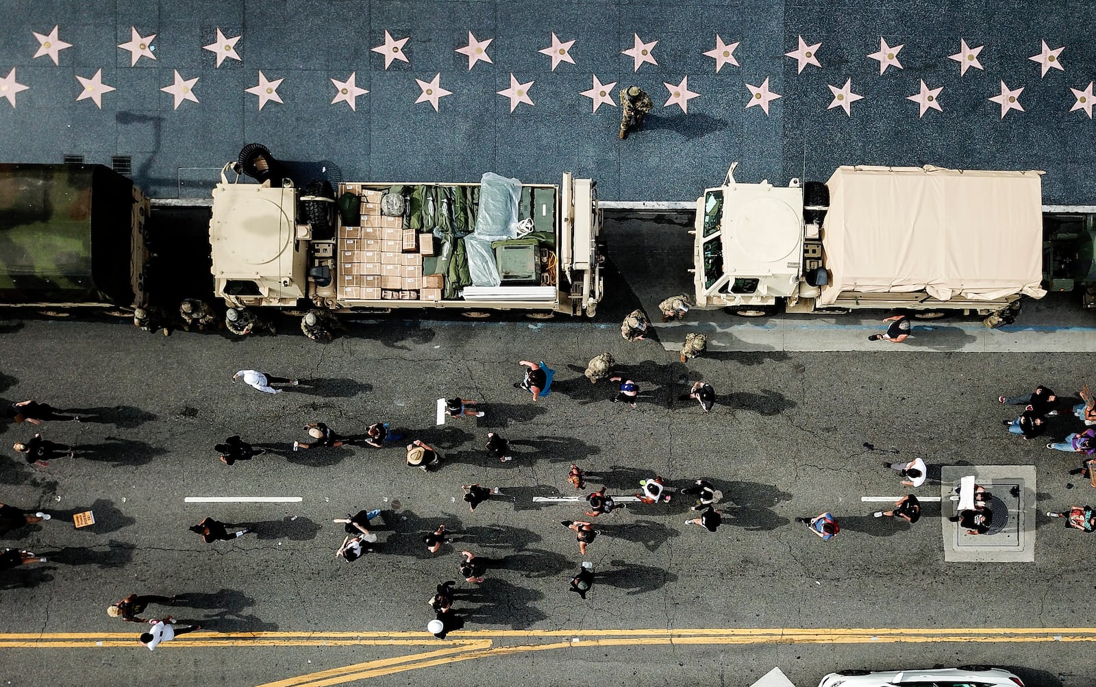 Members of the National Guard watch as demonstrators march along Hollywood Boulevard on Tuesday, June 2, 2020, in Los Angeles during a protest over the death of George Floyd who died May 25 after he was restrained by Minneapolis police. (AP Photo/Ringo H.W. Chiu)